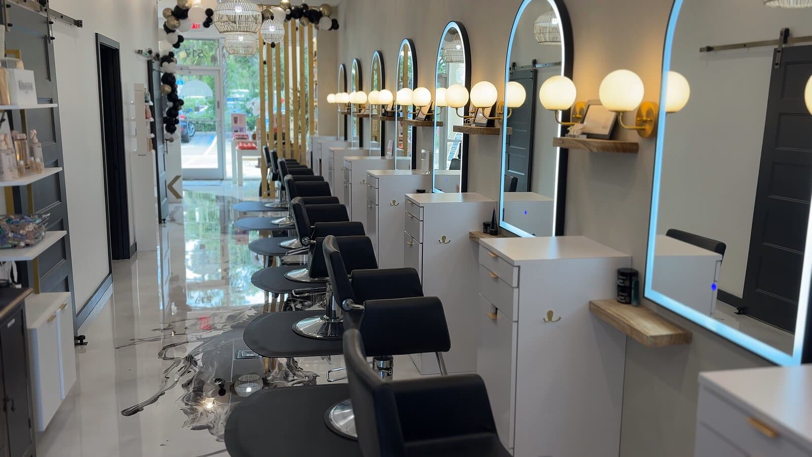 The row of styling stations at White Sand Salon with every sconce lit